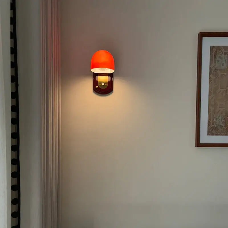 Applique murale avec support en bois marron et abat-jour orange

