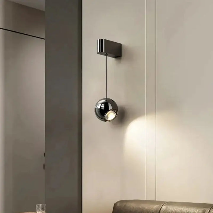 Applique murale suspendue avec une boule projetant la lumière

