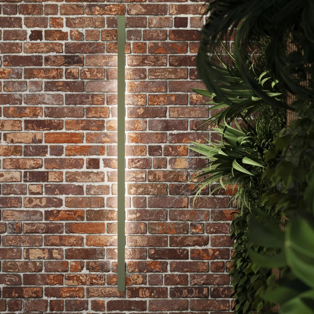 Applique murale lahti 90 led 4000k en vert olive mate montée sur un mur de briques ocre rouge rustique