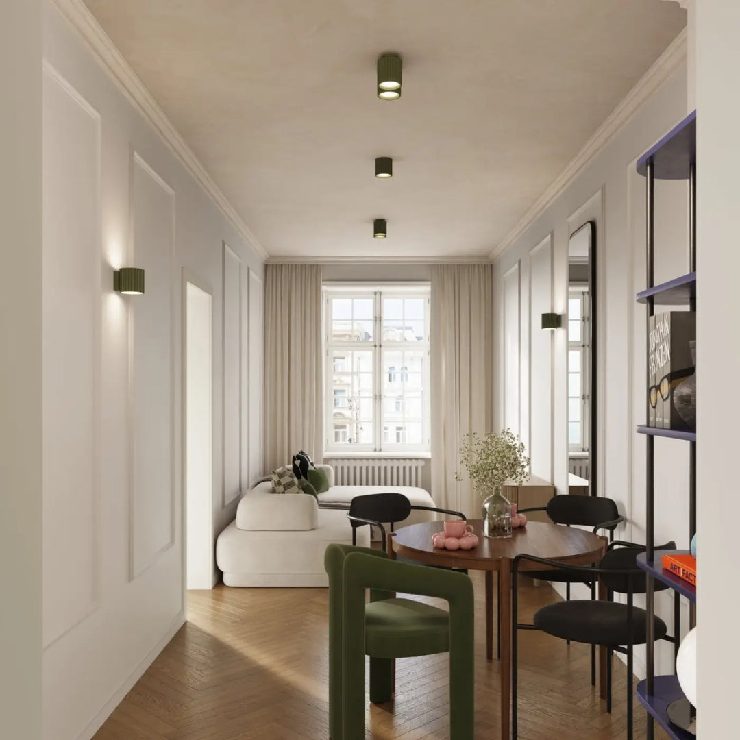 Applique murale aura vert olive avec forme unique inspirée près d’une table ronde en bois et chaises noires