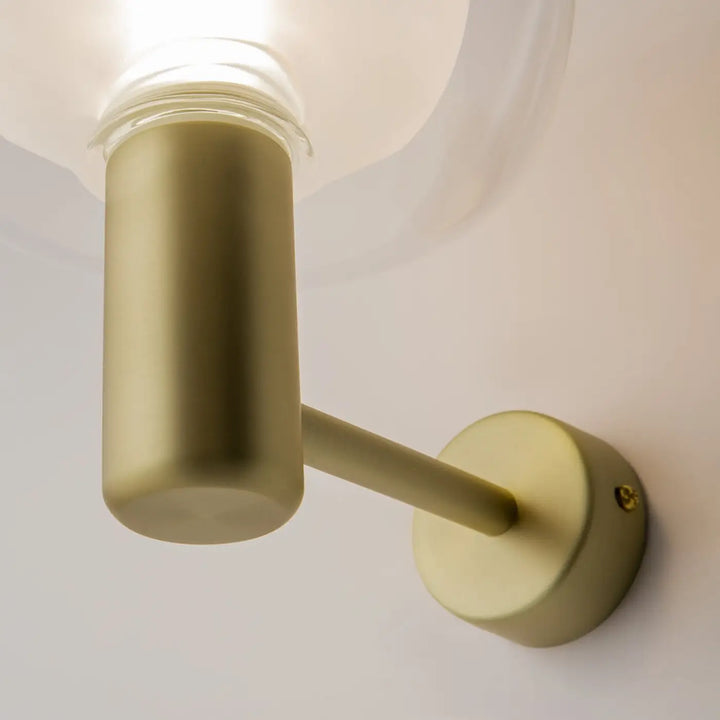 Applique murale double globe avec monture dorée mate et abat-jour cylindrique au design minimaliste