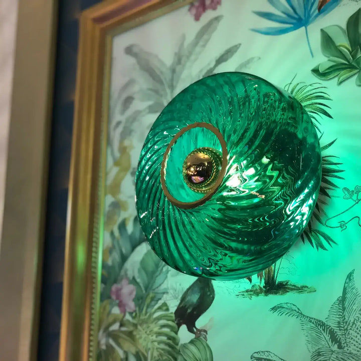 Applique roxanne en verre vert émeraude avec texture ondulée et anneau métallique doré dans un style art élégant
