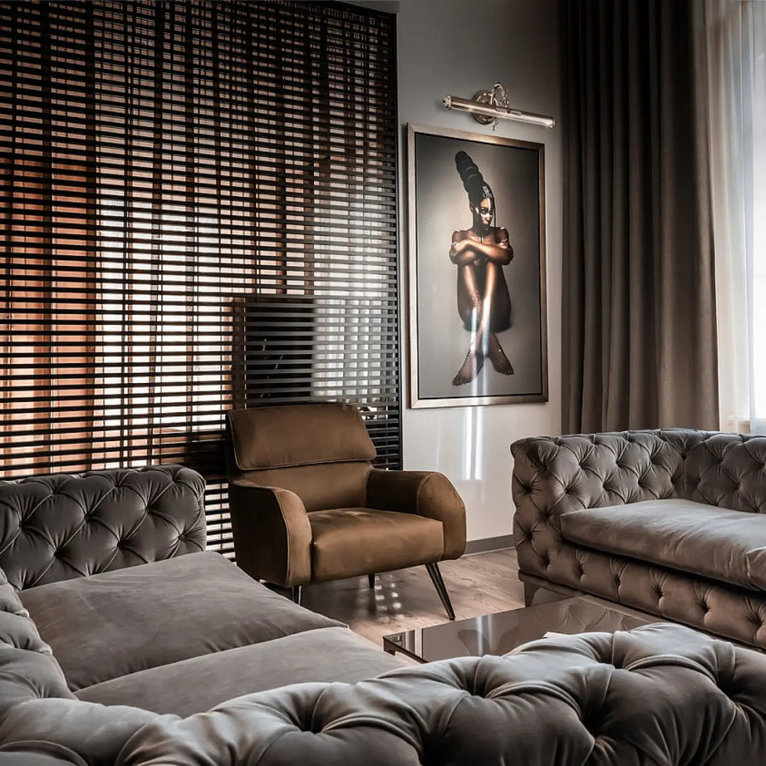 Canapé en velours tufté gris foncé avec ottomane et fauteuil assortis dans une pièce avec applique murale picasso bras déporté ampoules e14