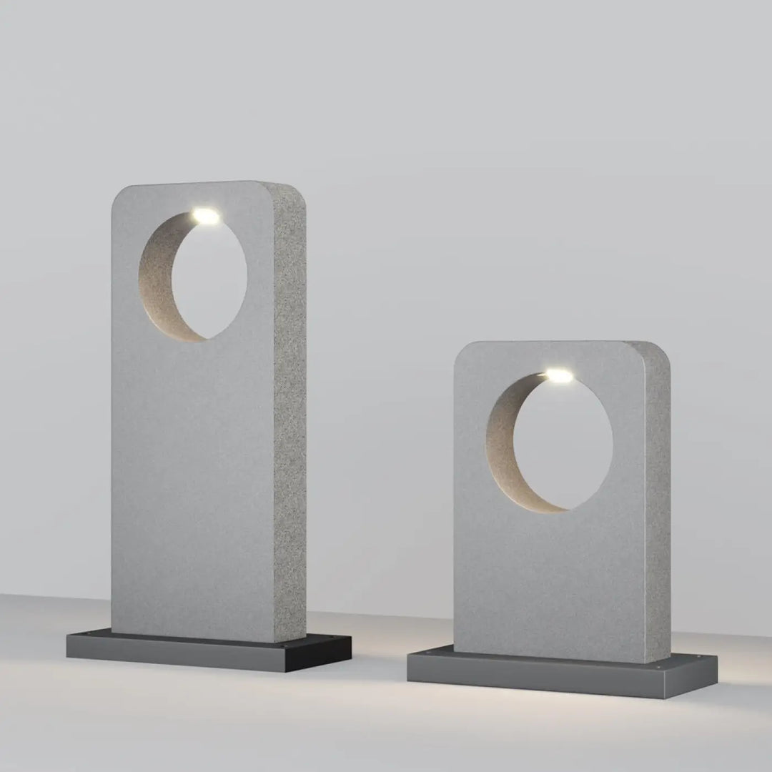 Borne extérieure en béton gris avec lampe moderne minimaliste à découpe circulaire et leds intégrées pour allée