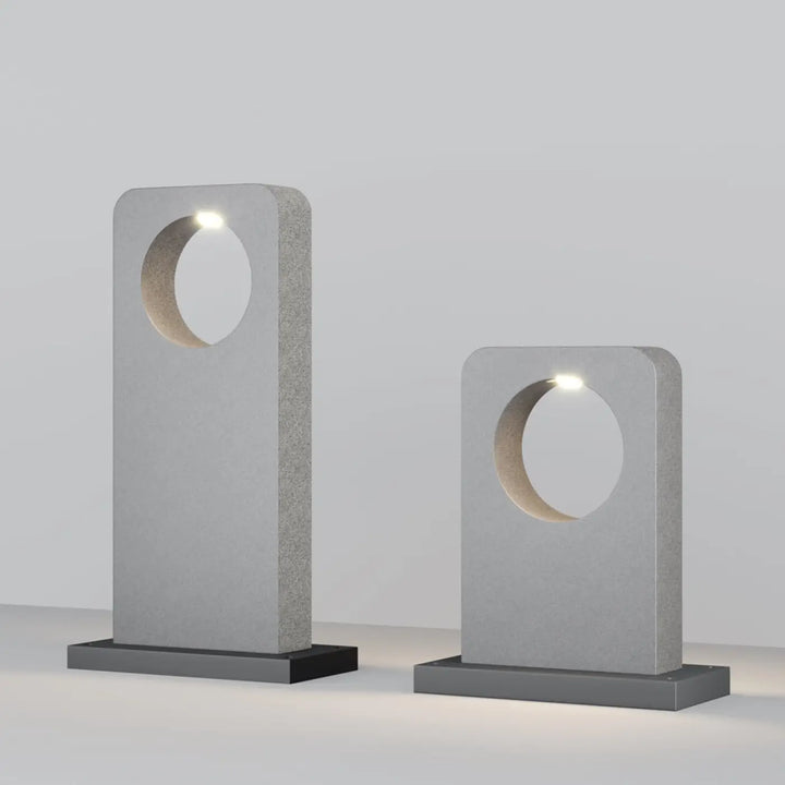 Borne extérieure en béton gris avec lampe moderne minimaliste à découpe circulaire et leds intégrées pour allée