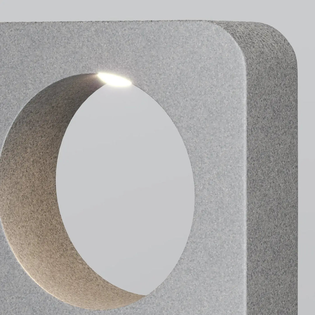 Borne extérieure en béton gris avec découpe circulaire illuminée, idéale pour un allée extérieure betone