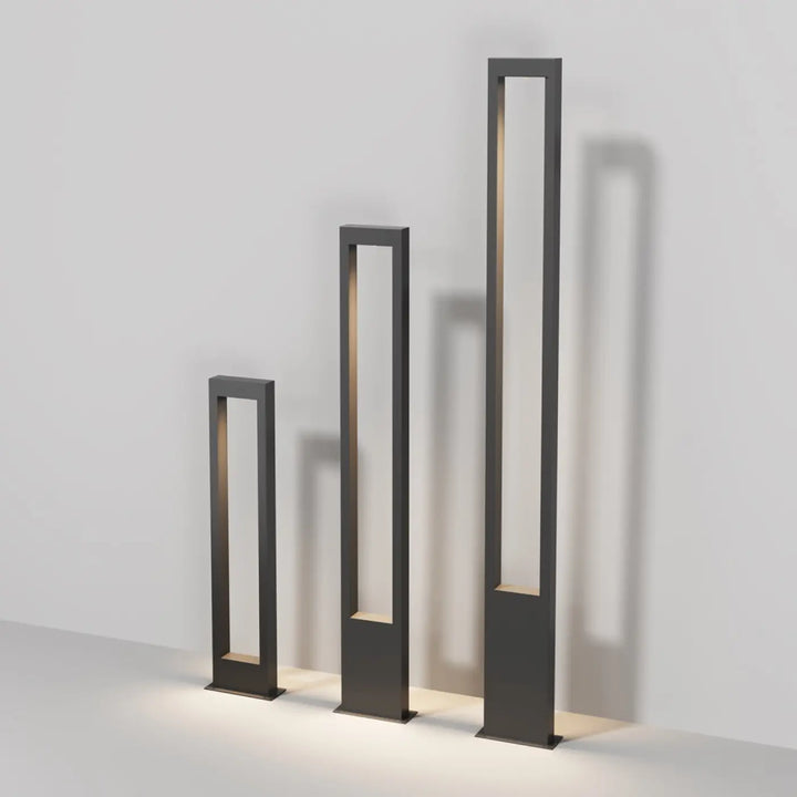 Trois bornes extérieures arche rectangulaires en métal graphite avec éclairage intérieur chaleureux et design minimaliste