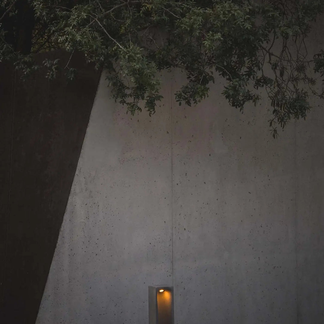 Borne Grot en ciment gris dans un jardin