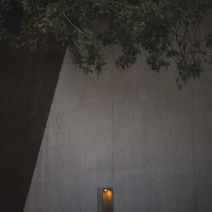 Borne Grot en ciment gris dans un jardin
