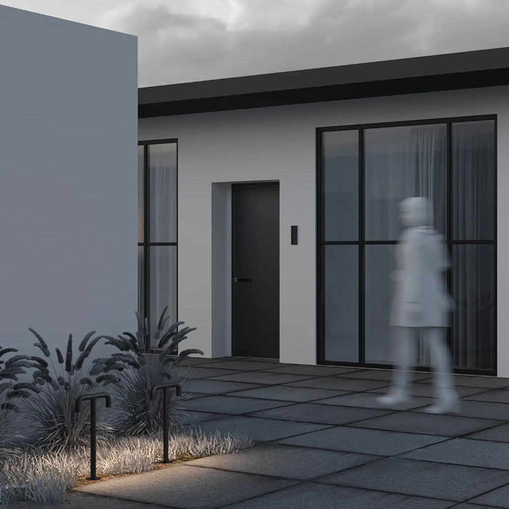 Borne extérieure led en aluminium noir avec base incurvée et tige fine émettant une lumière chaude elegante