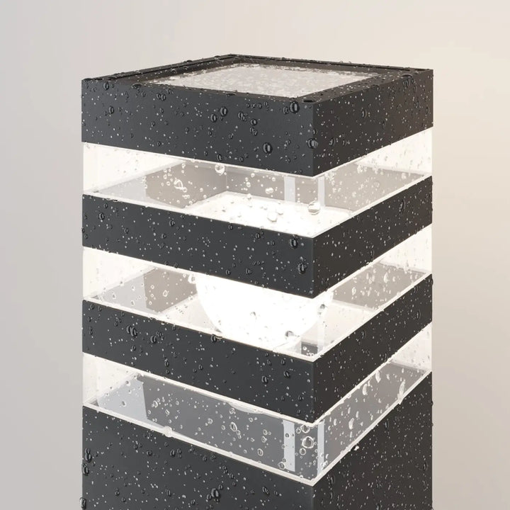 Borne extérieure en acier noir avec diffuseur vitré et design superposé moderne pour usage extérieur