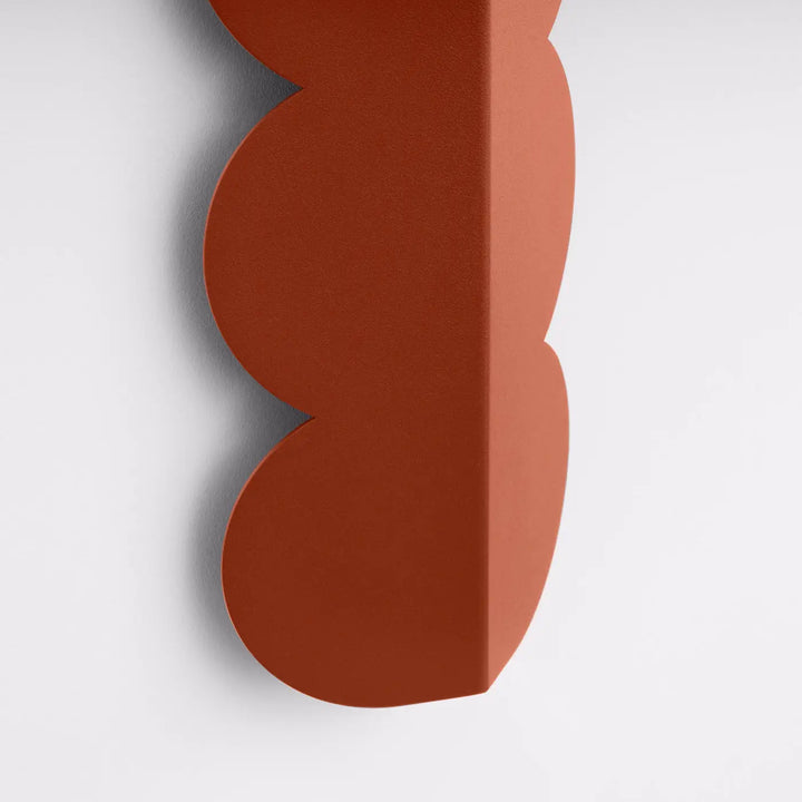 Applique murale biscuit rouge ochra en forme ondulée caractéristique avec finition mate terracotta et caractère distinctif