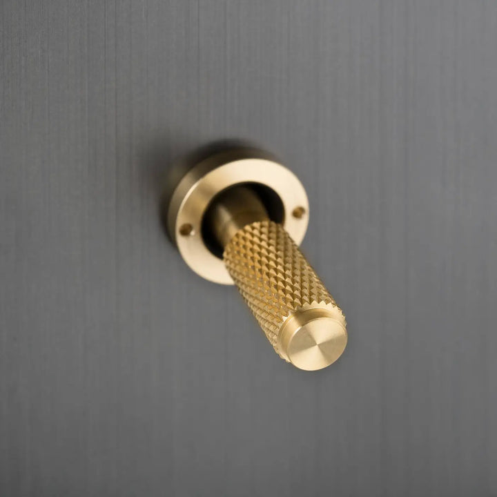 Détail d'un levier à gravure quadrillée, finitions bronze fumé et laiton #couleur_dor