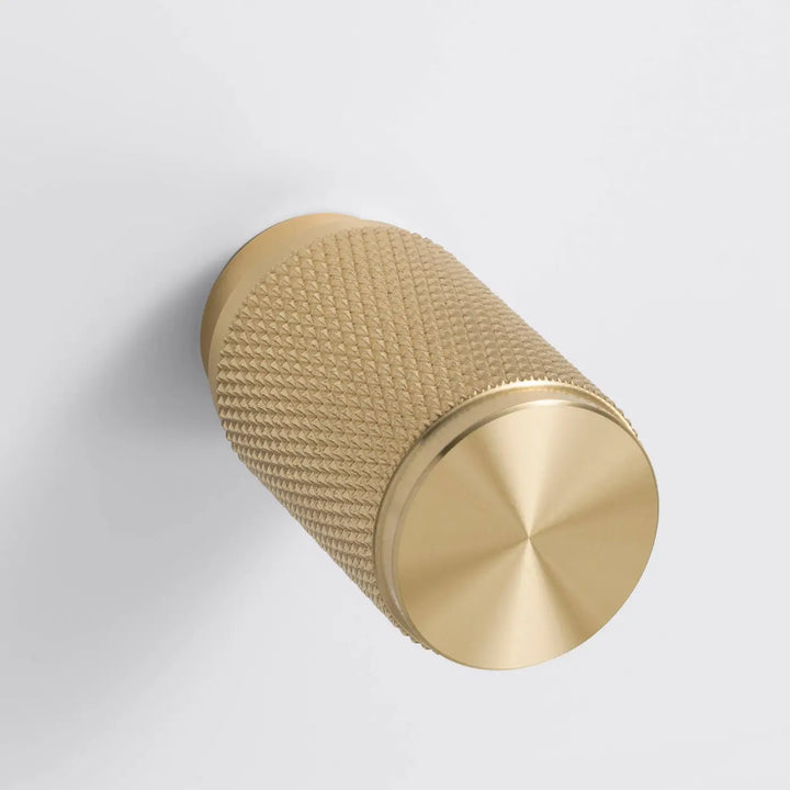 Détail d'un variateur à gravure quadrillée, finitions blanc et laiton #couleur_dor