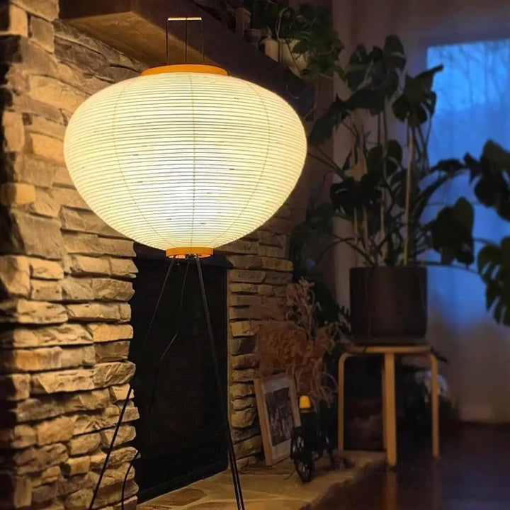 Lampadaire chloe avec sphère en papier lumineuse et base tripode en bois orange pour un design élégant plus qu’un simple éclairage