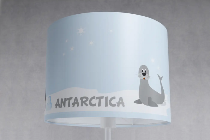 Lampadaire enfant bleu pastel avec abat-jour cylindrique illustré d’un phoque et texte antarctica en gris