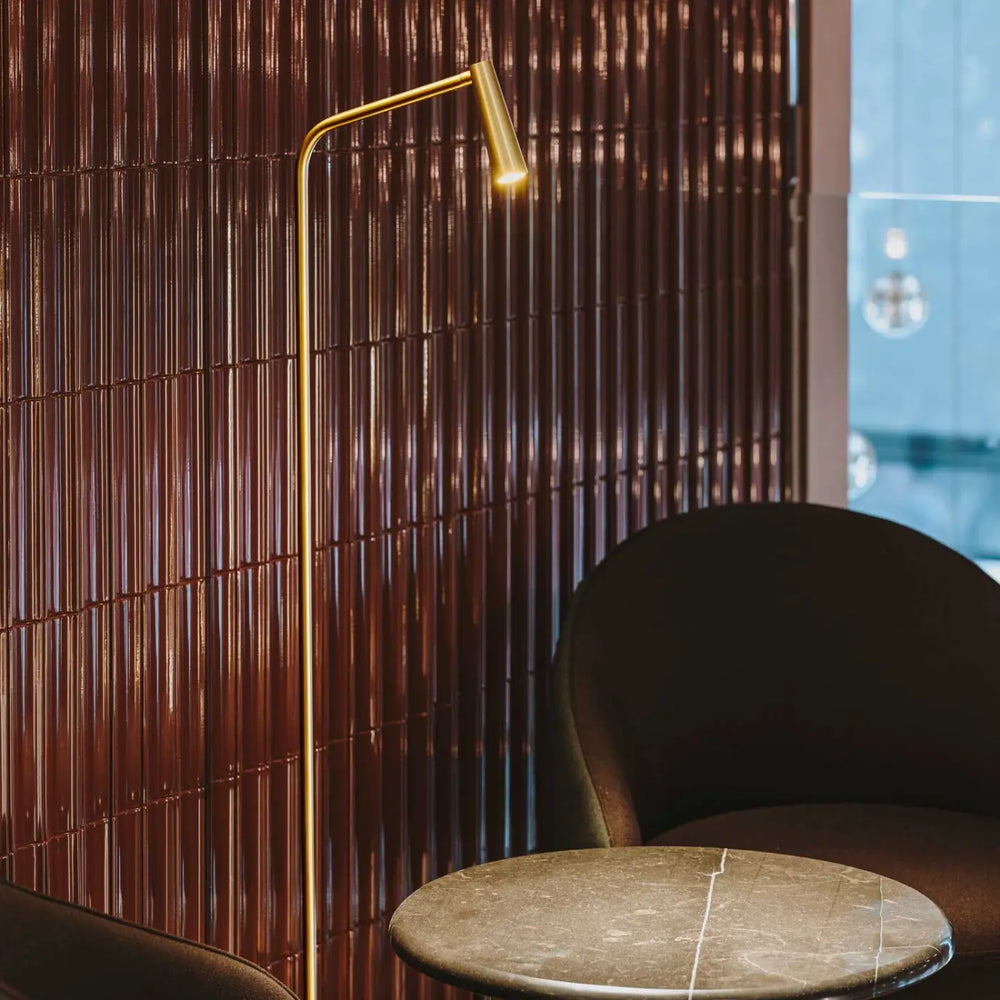 Lampadaire Gamma doré dans une pièce de vie