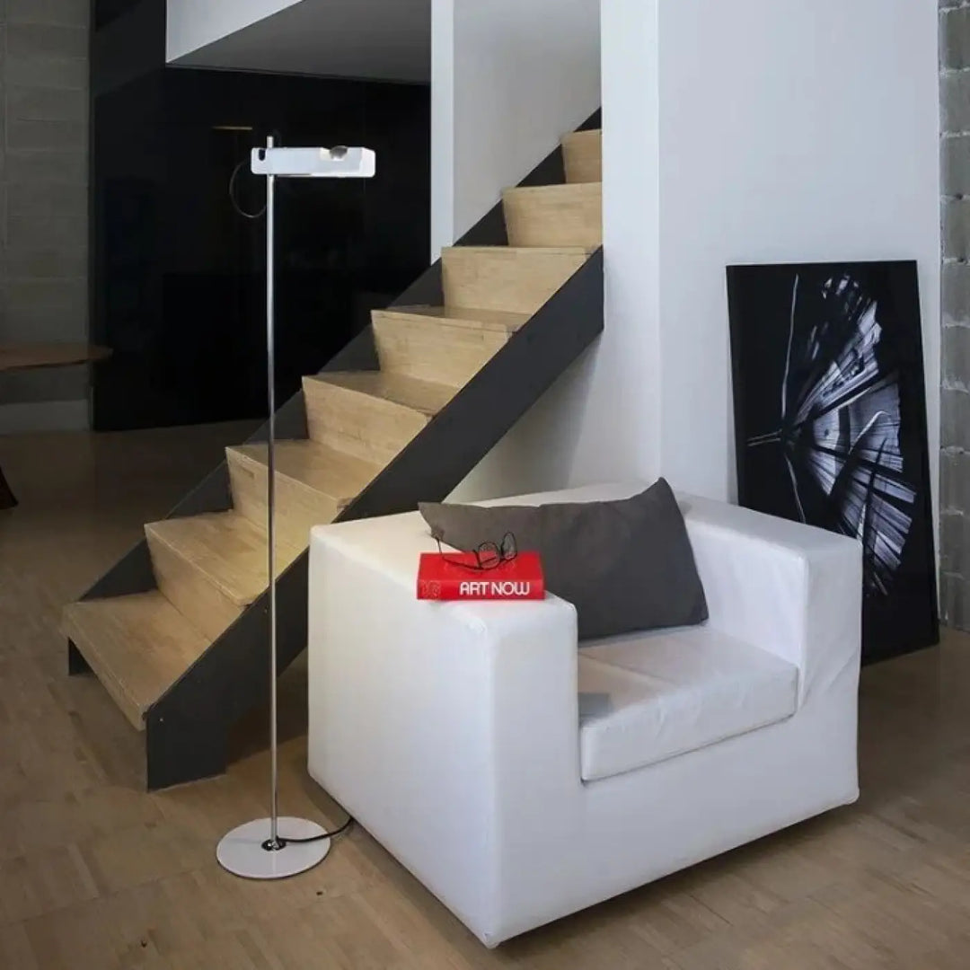 White leather armchair with gray cushion and red magazine illustrating structure fine for lampadaire moderne with éclairage directionnel