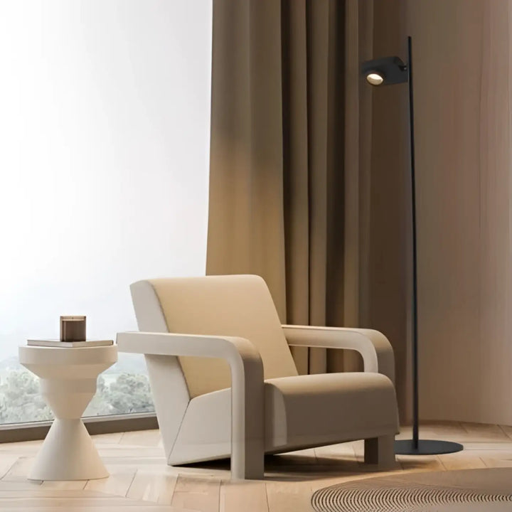 Cream-colored armchair with sleek modern design and smooth upholstery featured beside a lampadaire contemporain with spot ajustable luminaire capable lighting