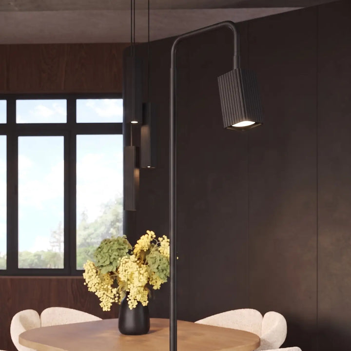 Lampadaire Rayo noir à spot rainuré près d'une table à manger
