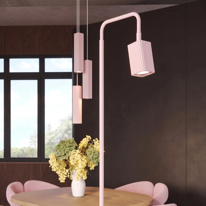 Lampadaire Rayo rose à spot rainuré près d'une table à manger