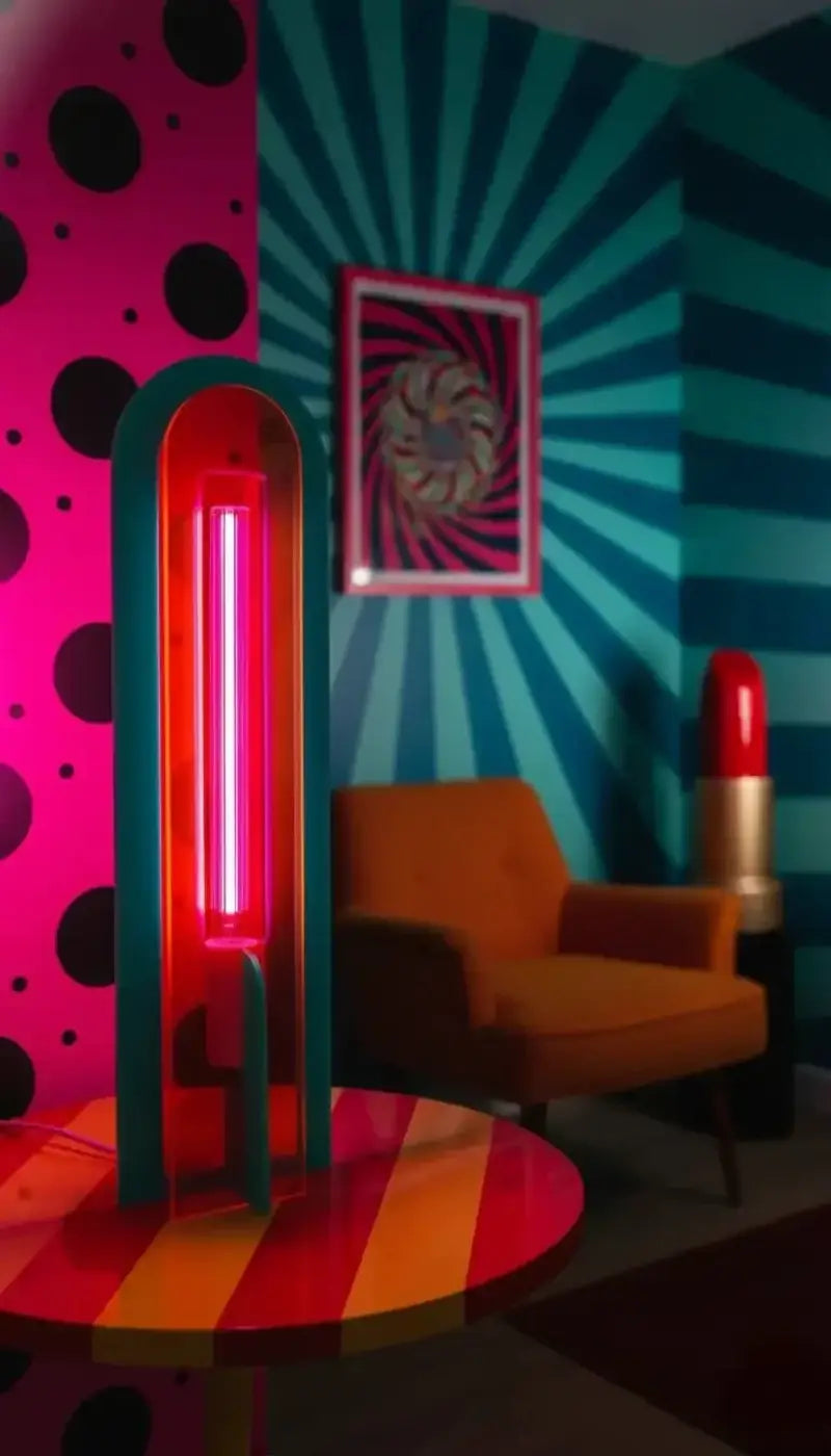 Lampe de chevet andy avec tube néon rouge vibrant encadré darc en teal sur table rayée acrylique coloré style pop art