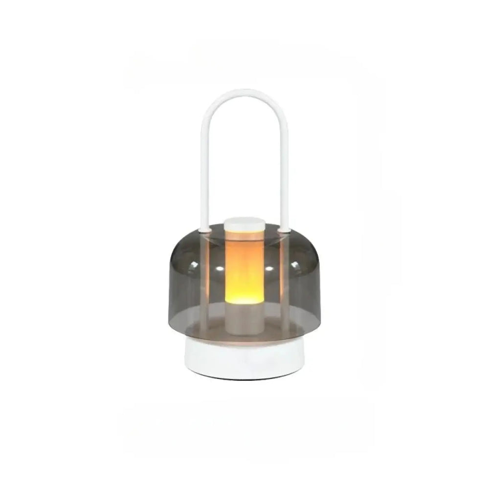 Lampe de table Cristo avec dôme gris translucide et base blanche émettant une douce lumière orange, idéal comme night light