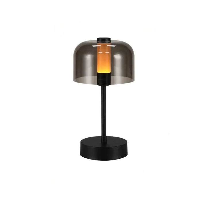 Lampe de table cristo en métal noir avec abat-jour en verre fumé diffusant une lumière orange chaleureuse idéale comme veilleuse