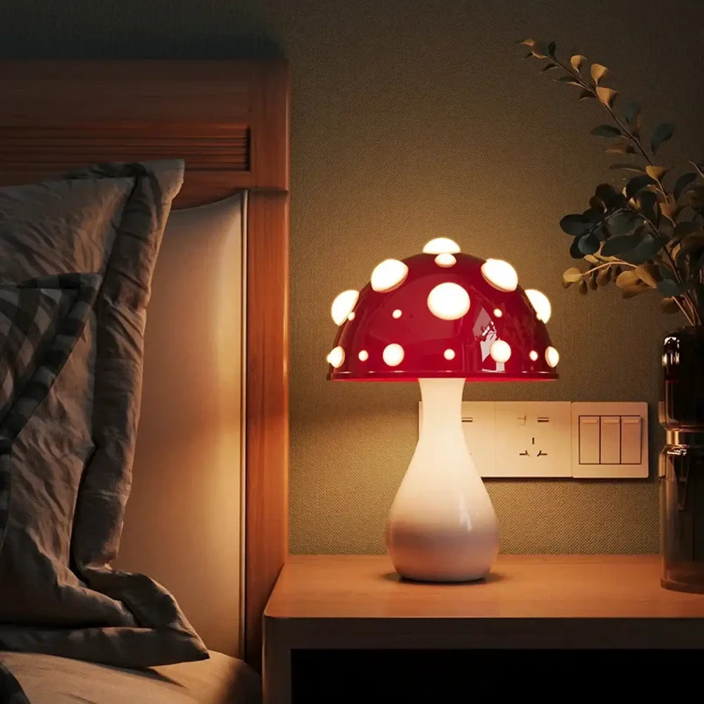 Lampe de chevet champignon rouge à pois blancs avec finition brillante sur table en bois pour ambiance douce