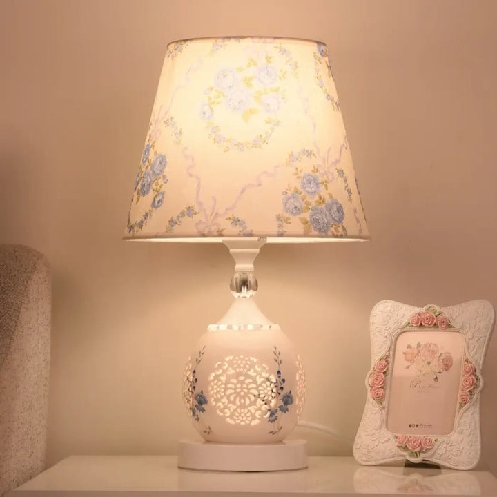 Lampe de chevet cristalline en céramique blanche avec motif floral bleu délicat et abat-jour pastel au design élégant qui attire lœil
