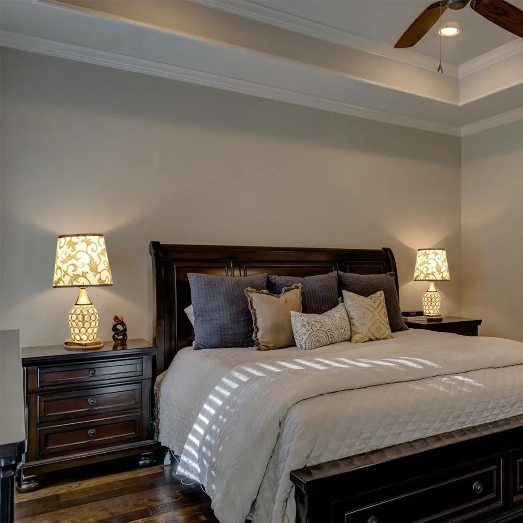 Lit traîneau en bois foncé avec couette blanche matelassée et coussins gris beige motifs design élégant attire l’œil