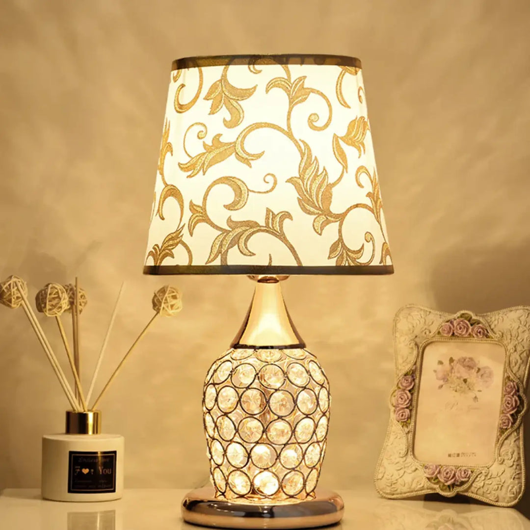 Lampe de chevet charlie avec abat-jour blanc orné de motifs feuilles d’or et base cristalline design élégant attire l’œil