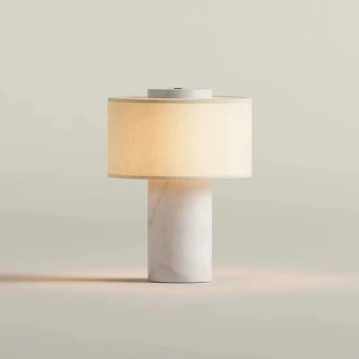 Lampe de chevet pietra avec base cylindrique en marbre blanc et abat-jour en tissu chaud pour une lumière douce