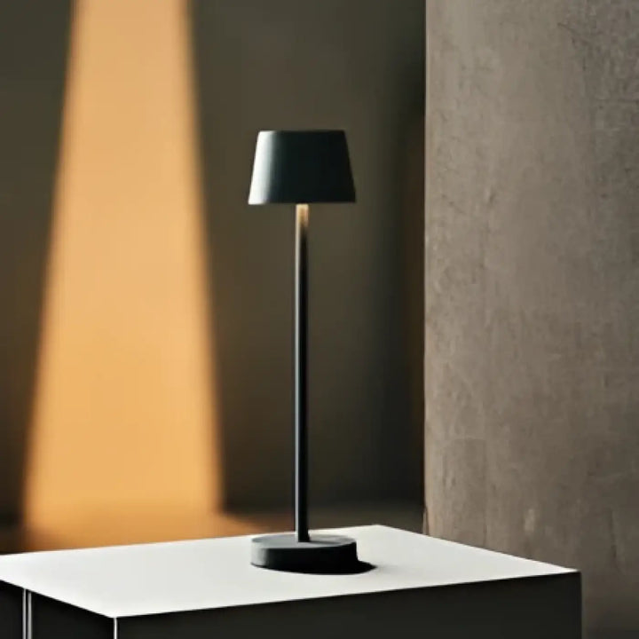 Lampe de chevet minimaliste noire avec base cylindrique et tige fine pour éclairage doux et facilité dentretien