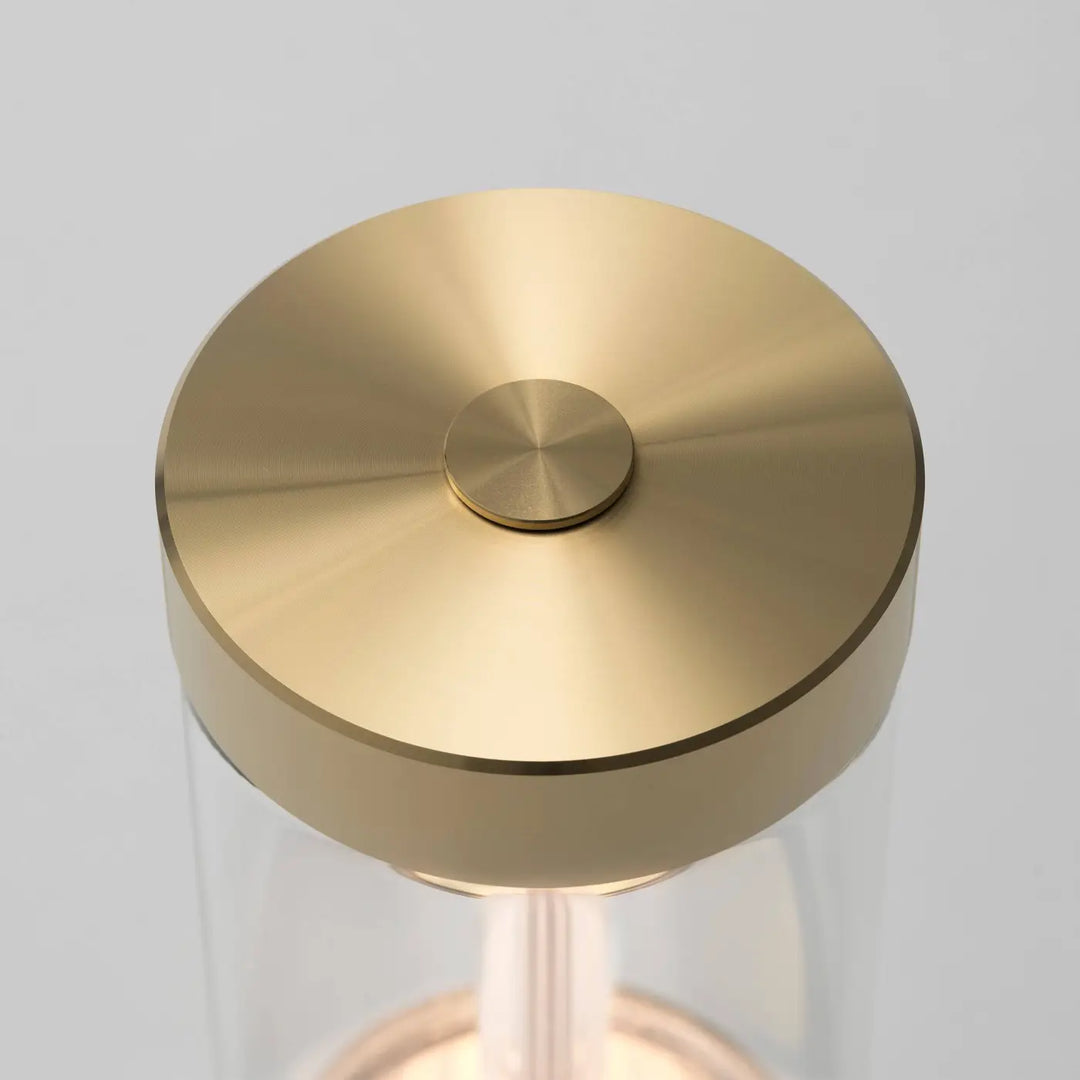 Détail de la lampe de chevet Takeout finition laiton, allumée #couleur_dor