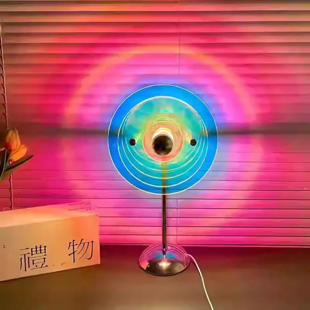 Lampe de chevet prisme rond décorative aux reflets colorés avec anneaux concentriques bleus et verts lumineux