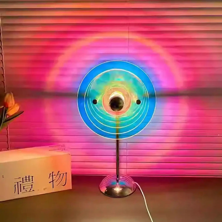 Lampe de chevet prisme rond décorative aux reflets colorés avec anneaux concentriques bleus et verts lumineux