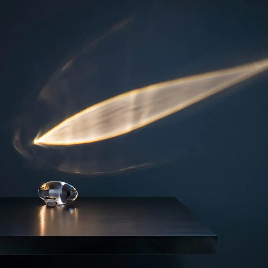 Lampe crystalia design cosmique s’inscrit avec un objet cristallin transparent et un accent métallique élégant sur surface sombre