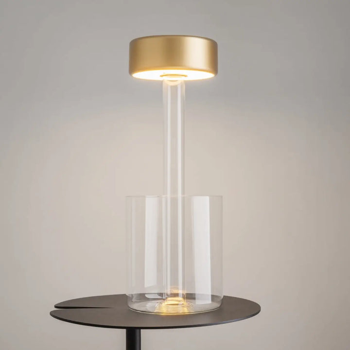 Lampe de chevet moderne avec lumière led dimmable, dessus circulaire doré et base en verre clair pour décoration florale