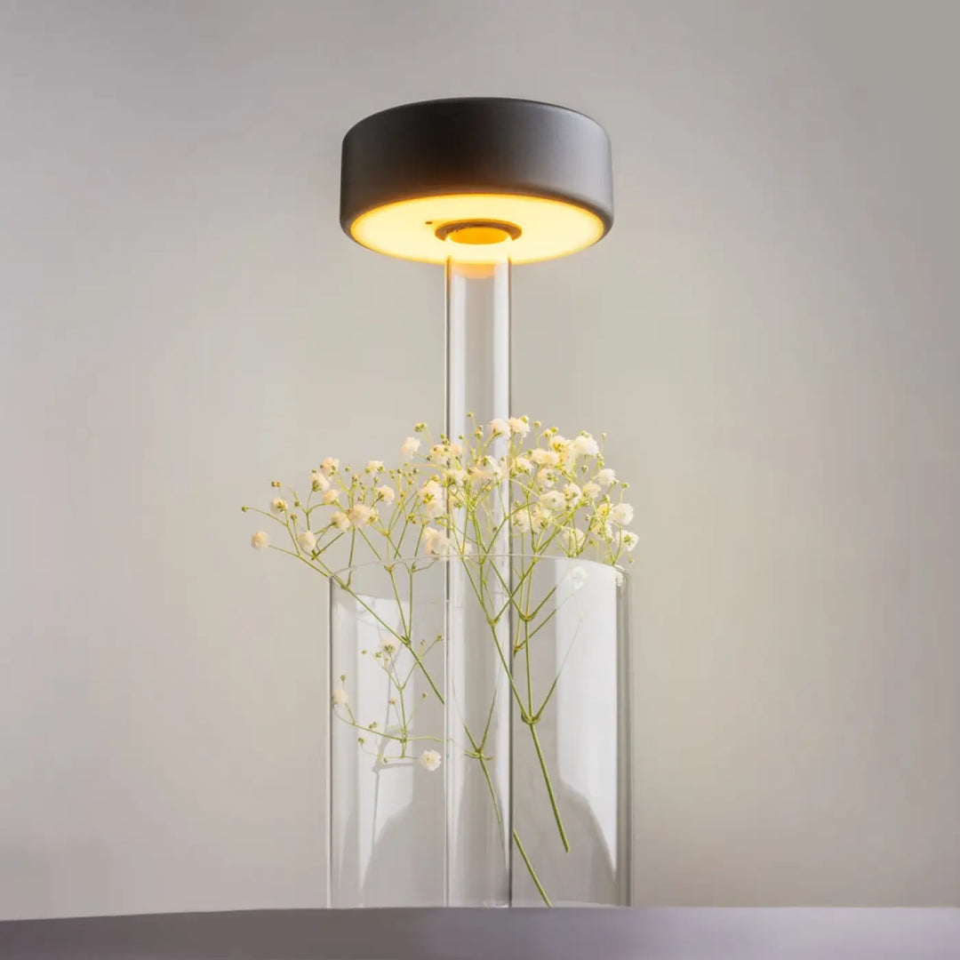 Lampe de chevet moderne avec lumière led dimmable, abat-jour noir, tige en verre transparente et décoration florale délicate