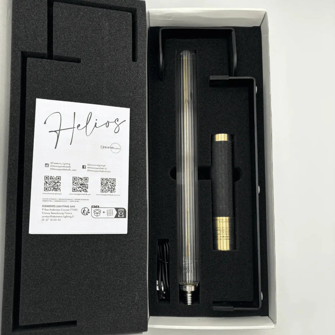 Lampe de chevet helios avec corps cylindrique transparent et poignée noire texturée comme objet lumineux led