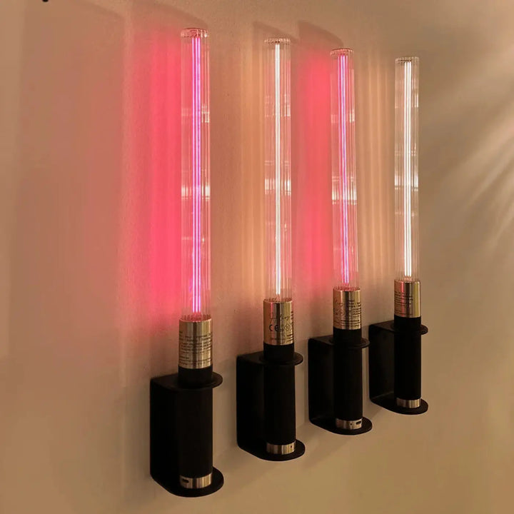 Lampe de chevet hélios avec quatre objets lumineux cylindriques en verre transparent émettant une lueur néon rose et blanche
