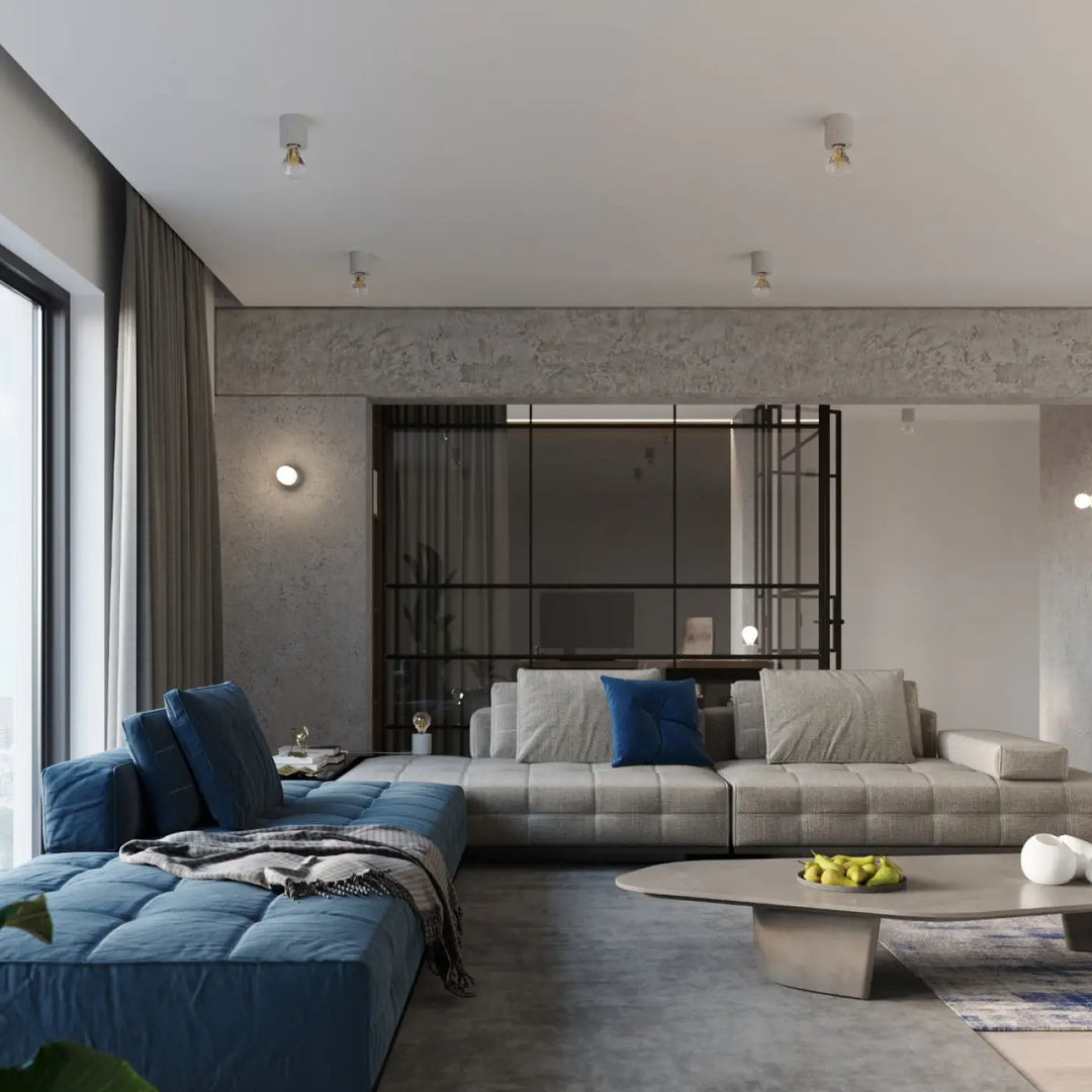 Lampe a poser béton salgado style loft avec canapé sectionnel moderne gris clair et coussins bleus profonds
