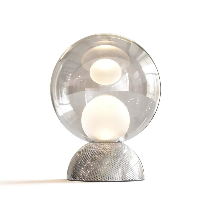 Lampe de chevet charmpossant une sphère lumineuse cachée en verre transparent avec base métallique texturée argentée