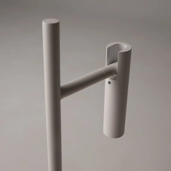 Minimalist white metal coat rack with sleek cylindrical design and horizontal arm for garment hanging by lampe de chevet estudo liseuse led