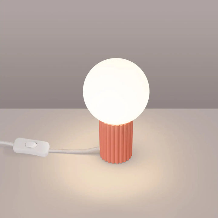Lampe a poser halo peach avec base corail texturée cylindre et ampoule sphérique blanche lumineuse moderne