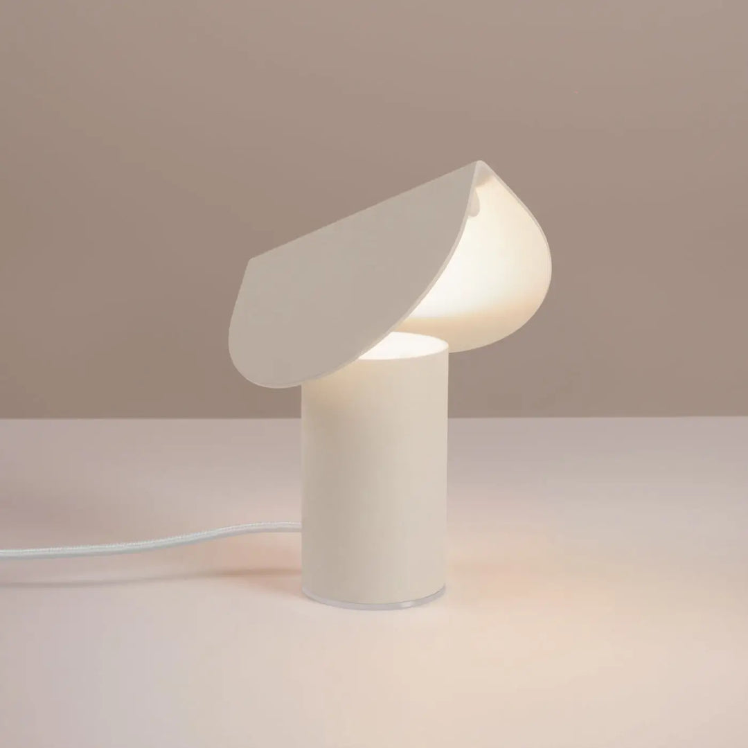 Lampe à poser BISCUIT beige allumée, sur une table