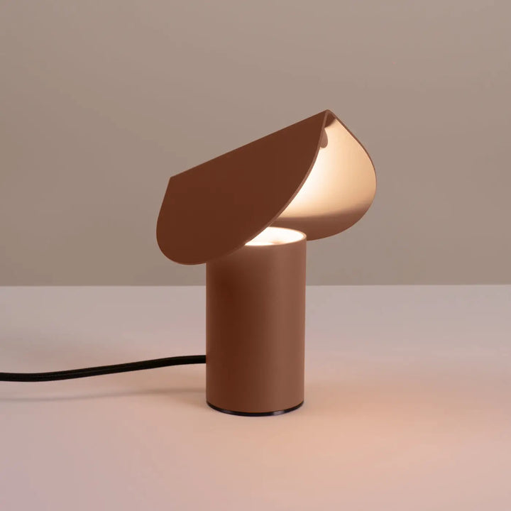 Lampe à poser BISCUIT moka allumée, sur une table