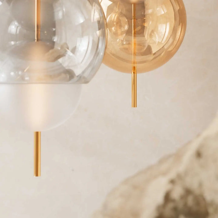 Lampe suspendue galileo avec globes en verre clair et ambré suspendus par tiges fines dorées