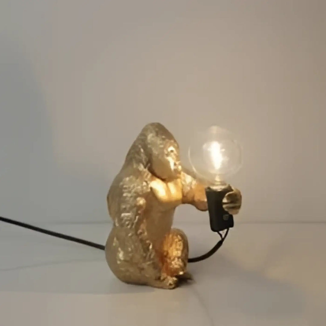 Lampe de table gorenzo artistique gorille dorée tenant une ampoule lumineuse table artistique gorille élégante